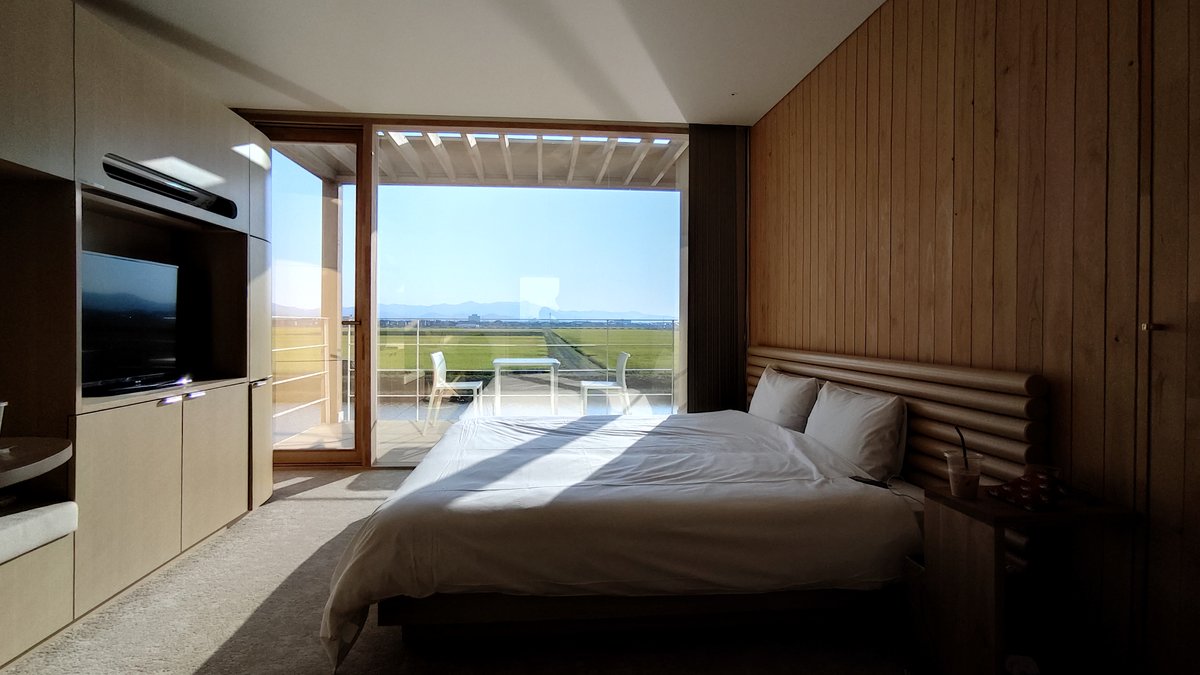 SUIDEN TERRASSEの客室と窓の外に広がる田んぼ